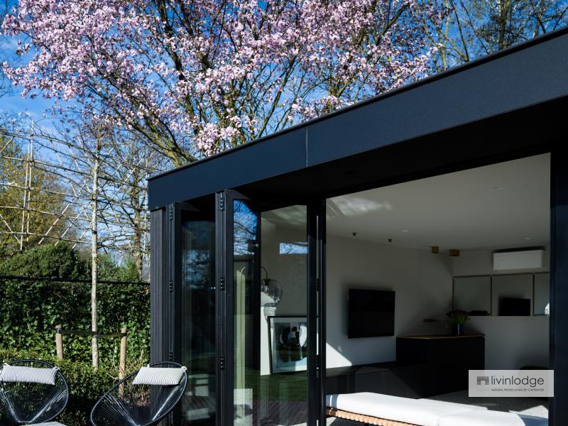 Ambiance printanière autour d’un pool house moderne noir